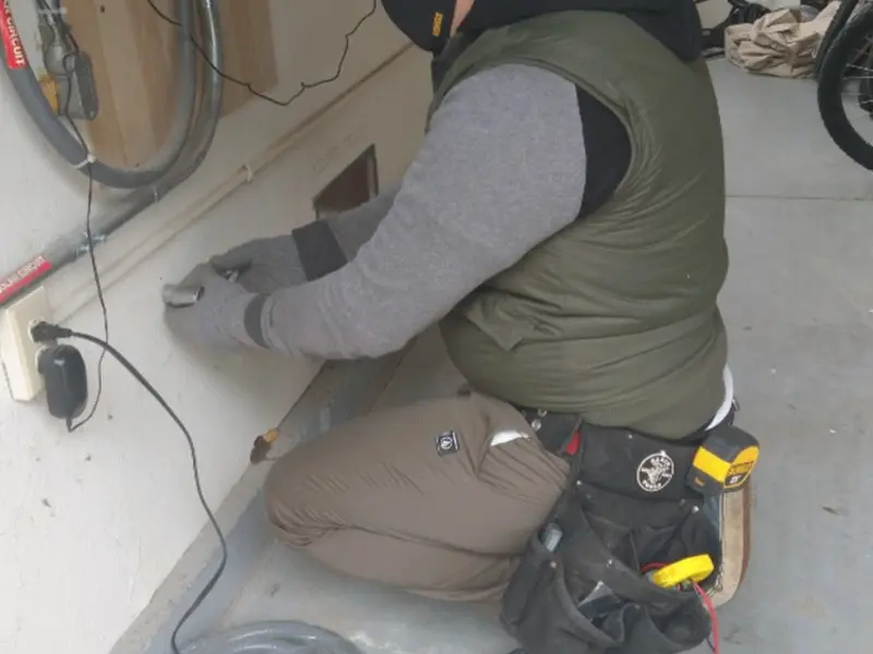 Electrician performing outlet wiring in a Taylor Creek garage